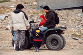 Inuit mother talks to a teacher riding a quad bike in the street. Scoresbysund East Greenland. 2005