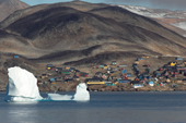 An iceberg floats by the Inuit village of Scoresbysund on the coast of Scoresbysund Fiord. East Greenland. 2005