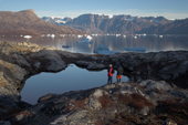 Tourists in a dramatic East Greenland landscape with a lake, mountains, icebergs and Glaciers from Renodde. 2005
