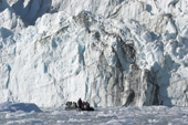 Ice cliffs of the Eielson Glacier tower over a tourist zodiac. Rypefjord. East Greenland. 2005