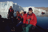 Manfred Tschipper sits at the front of the Zodiac as it cruises the Eielson Glacier in Rype Fiord. Scoresbysund. East Greenland. 2005