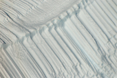 Parallel ridges on the side of a now tilted iceberg were caused by air bubbles rising to the surface. East Greenland. 2005
