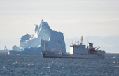 Aleksey Maryshev is dwarfed by a huge iceberg beyond her. Scoresbysund Fiord. East Greenland. 2005