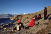 Warmly dressed tourists enjoy the autumn sunshine close to the historic Thule Culture site at Sydkap. Scoresbysund Fiord. East Greenland. 2005