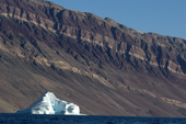 Iceberg by dramatic sedimentary cliffs in Eleonora Bay. North-east Greenland National Park. 2005