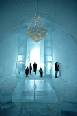 Visitors to the Ice Hotel in the main hall with the ice chandelier. Jukkasjarvi. Sweden. 2003