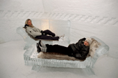 Girls rest on the ice seats in the Roman Suite, Ice Hotel. Jukkasjarvi. Sweden. 2003