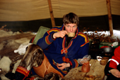 Sami man drinks coffee from a wooden cup while inside a lavvu. Jukkasjarvi. Sweden. 2003