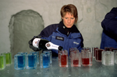 Barmaid tops up brightly coloured cocktails in Ice glasses. Ice Hotel. Jukkasjarvi. Sweden. 2003