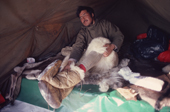 Inuit hunter, Ituko, takes off his fur clothing, in a tent, whilst on a hunting trip. Northwest Greenland. 1980