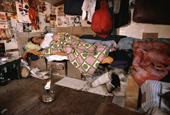 Inuk, Asiajuk asleep in hunters hut, with stove for warmth. His sealskin kamik are nearby. N. W. Greenland. 1980