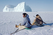 Inuit hunters, Ituko & Ajako, take a rest while out hunting walrus on new sea ice near Moriussaq. Northwest Greenland. (1980)