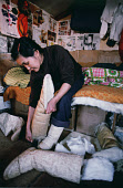 In a hut at Narssarssuk, Saufak Kivioq,, an Inuit woman, prepares her husband's sealskin kamik (boots) before a day's hunting. Avanersuaq. Northwest Greenland. (1980)