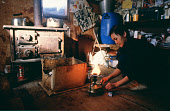 In a hut at Narssarssuk, Saufak Kivioq, an Inuit woman, lights a Primus stove. Avanersuaq. Northwest Greenland. (1980)