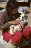 Inuit girl holding a husky puppy at a hunting camp. Northwest Greenland. 1980