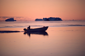 An Inuit hunter out in his boat at sunset in the autumn. N.W. Greenland. 1987