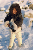 An Inuit girl, Sofie jensen, warmly dressed in a fox fur hooded jacket (kapataq) and long sealskin kamik (boots). Thule, Northwest Greenland. (1987)
