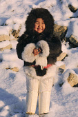 Sofie Jensen, a young Inuit girl, warmly dressed in a fox fur hooded jacket (kapataq) and long sealskin kamik (boots). Qaanaaq, Northwest Greenland. (1987)