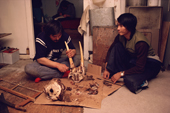 Young Inuit men cleaning a walrus skull, after a successful hunt. Northwest Greenland. 1987