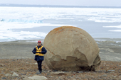 Tourist poses infront of one of the remarkable spherical stones on Champ Island. Franz Josef Land, Russia. 2004