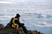 A tourist looks out across melting sea ice off Cape Heller, Wilczek Land. Franz Josef Land. 2004