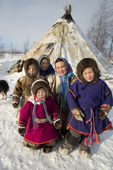 At a Nenets reindeer herders' camp, women & children members of the Serotetto family pose outside their reindeer skin tent. Yamal, NW Siberia, Russia