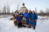 At a Nenets reindeer herders' camp, members of the Serotetto family pose outside their reindeer skin tent. Yamal, NW Siberia, Russia