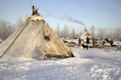 On a fine day, members of the Serotetto family work outside at their winter camp on the edge of a forest. Yamal, NW Siberia, Russia