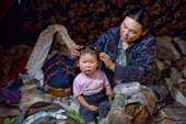 Inside her family's tent, Raisa Serotetto, a Nenets woman, does the hair of her two year old daughter, Daria. Yamal, NW Siberia, Russia