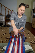 Valya Khudi, weaving a woollen Nenets man's belt on a traditional hand loom. Yar-Sale, Yamal, NW Siberia, Russia.