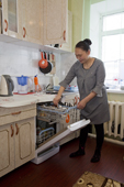 Valya Khudi,a Nenets woman, unloading the dish washer in the modern kitchen of her family's apartment in Yar-Sale, Yamal, NW Siberia, Russia.