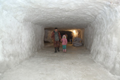 Maxim Nyatch, a Nenets fisherman, walking with is daughter, Amelia, inside an ice house by the Yuribey River. The ice house is used to freeze and store fish. It was built into the permafrost, 20 feet under the surface of the tundra and covers an area of 900 square metres. Gydan Peninsula, Yamal, Siberia, Russia