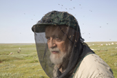 Photographer Bryan Alexander, wearing a head net for protection against mosquitoes while photographing on a hot summer day in the Tazovsky region of the Gydan Peninsula, Yamal, Siberia
