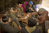 Young Nenets reindeer herders playing cards in the evening after finishing their work. Gyda, Tazovsky region, Yamal, Siberia, Russia