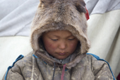 Vitally Yaptunay, a young Nenets boy, wearing a traditional Malitsa (hooded reindeer skin coat). Gyda, Tazovsky region, Yamal, Siberia, Russia