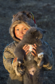 Vitally Yaptunay, a young Nenets boy, from a reindeer herding family, holding a puppy called Tovik. Gyda. Tazovsky region, Yamal, Siberia, Russia