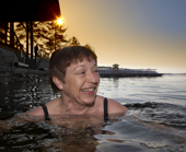 A woman swimming in winter, in freezing cold water. Jeris Ski resort, Yllas, Lapland, Finland. MR