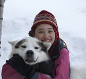 Young girl with Husky sled dog. Kiruna, Lapland, Sweden.