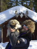 Man in fur hat with Husky sled dog at Mushers Lodge, Kiruna, Lapland, Sweden. MR