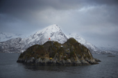 Rocky island in the Lofoten Isles with small lighthouse. Lapland, Norway.