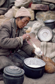 Herder's wife ladles Yak milk into a skin. Nimaling Plateau. Ladakh. India.